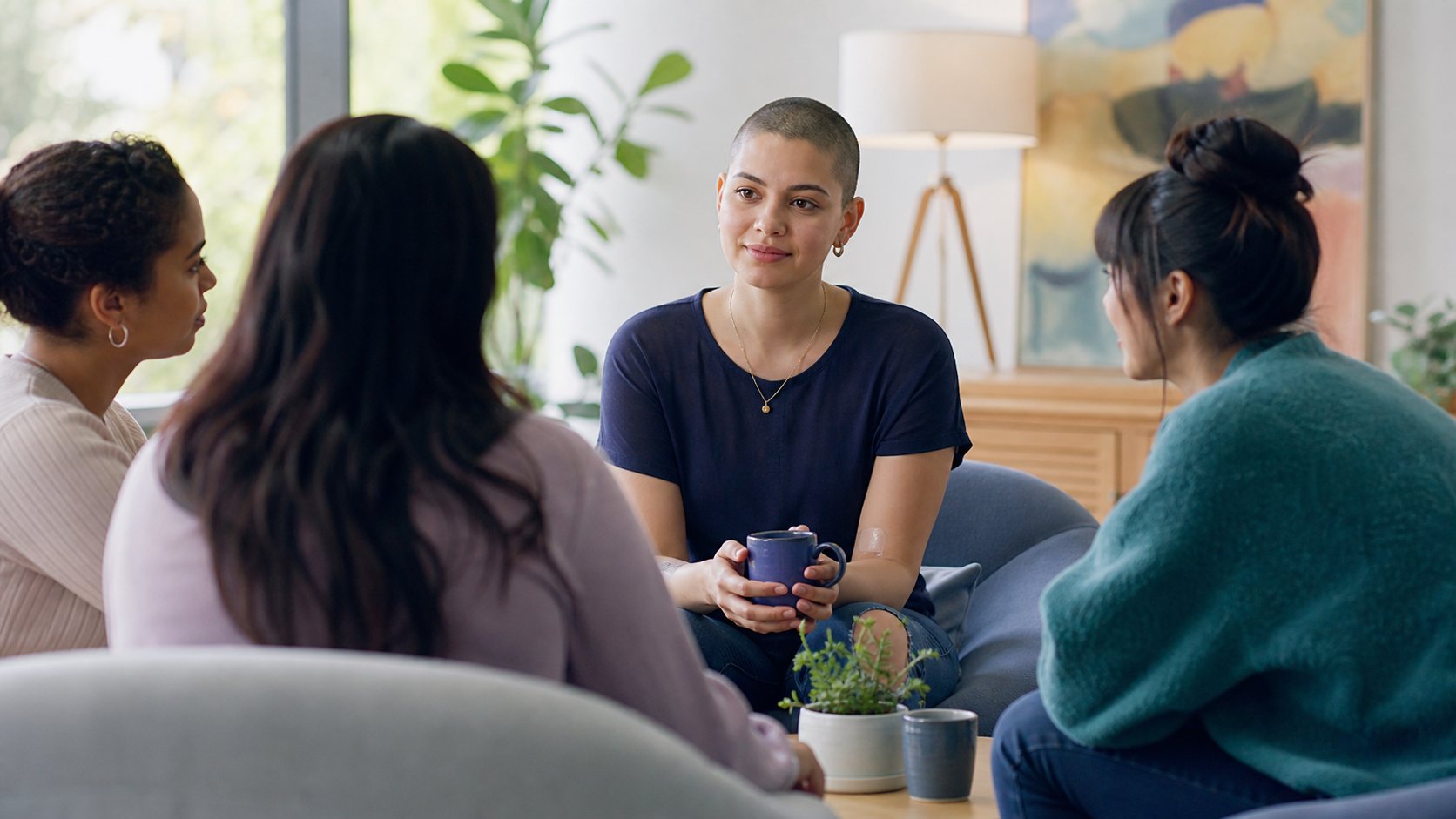 A young adult talking with friends in a bright living room