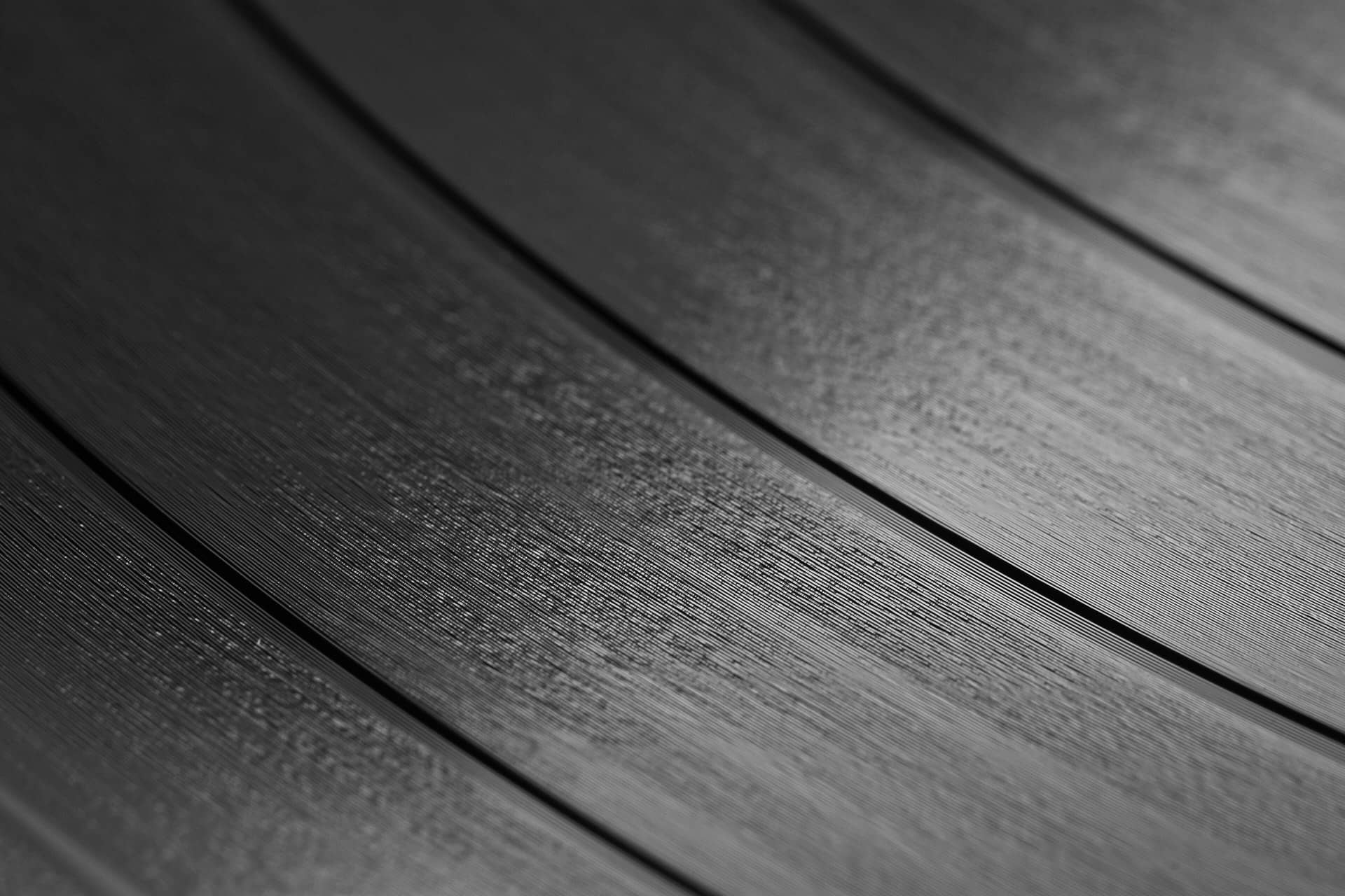 Close macro view of the grooves of a black vinyl record.