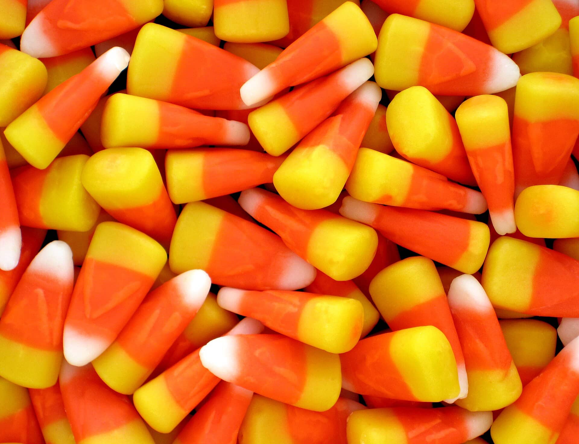 Close view of orange, yellow and white candy corn pieces.